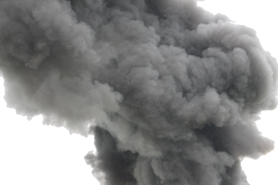 black smoke bills from the top of a building