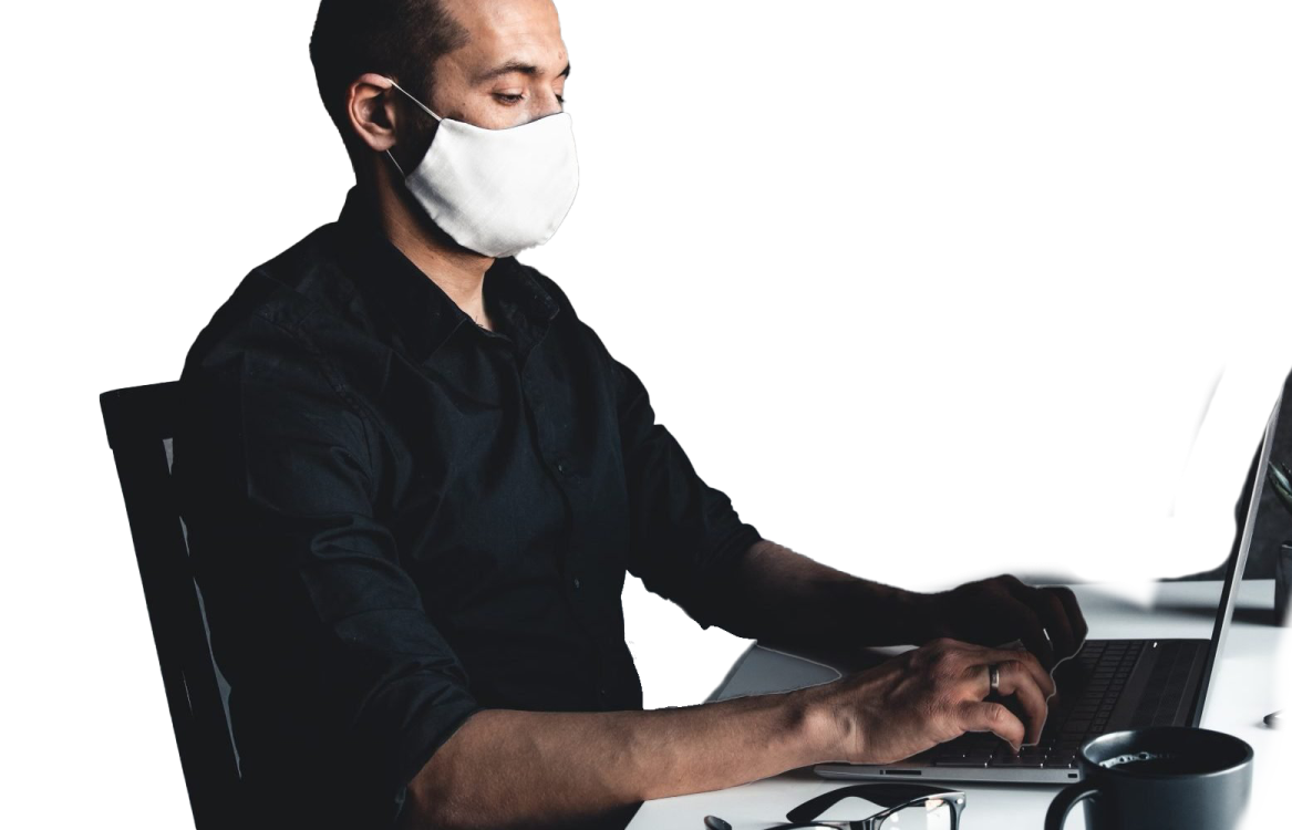 a man wearing a face mask while working on his laptop