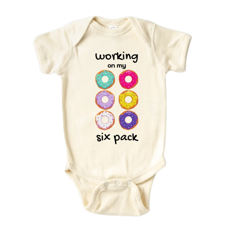 a baby bodysuit with the words working six pack on it