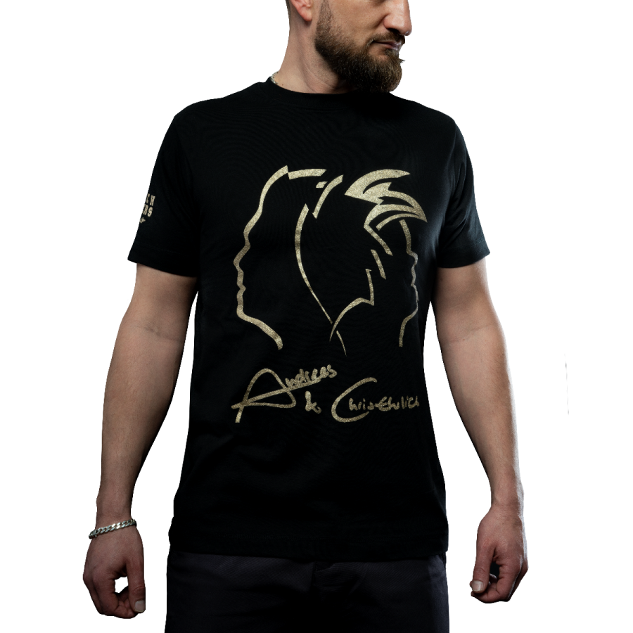 a man wearing a black t - shirt with gold foil on it
