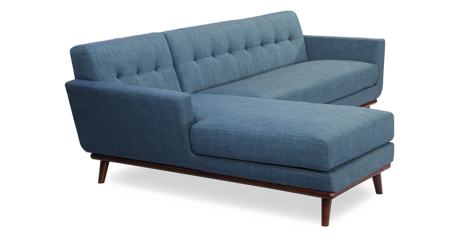 a blue sofa with dark wood legs
