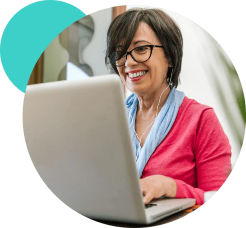 a woman sitting in front of a laptop and smiling