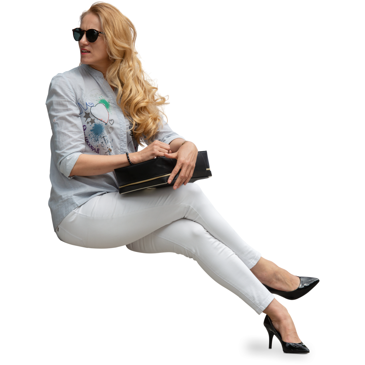 a woman sitting on the ground holding a purse