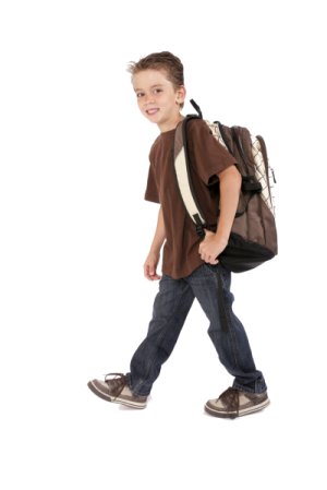 a young boy walking with a backpack on his back