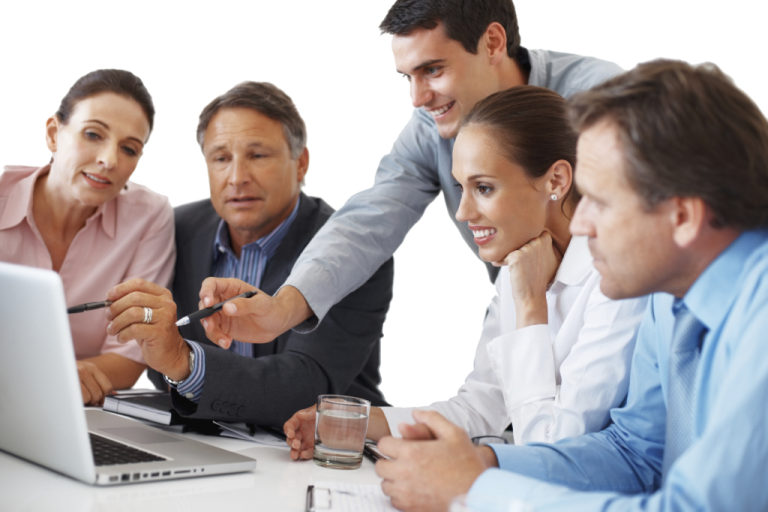 a group of people sitting around a laptop