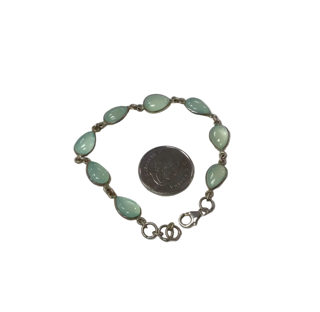 a silver bracelet with green glass beads