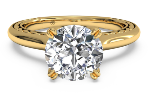 a yellow gold engagement ring with a round brilliant diamond