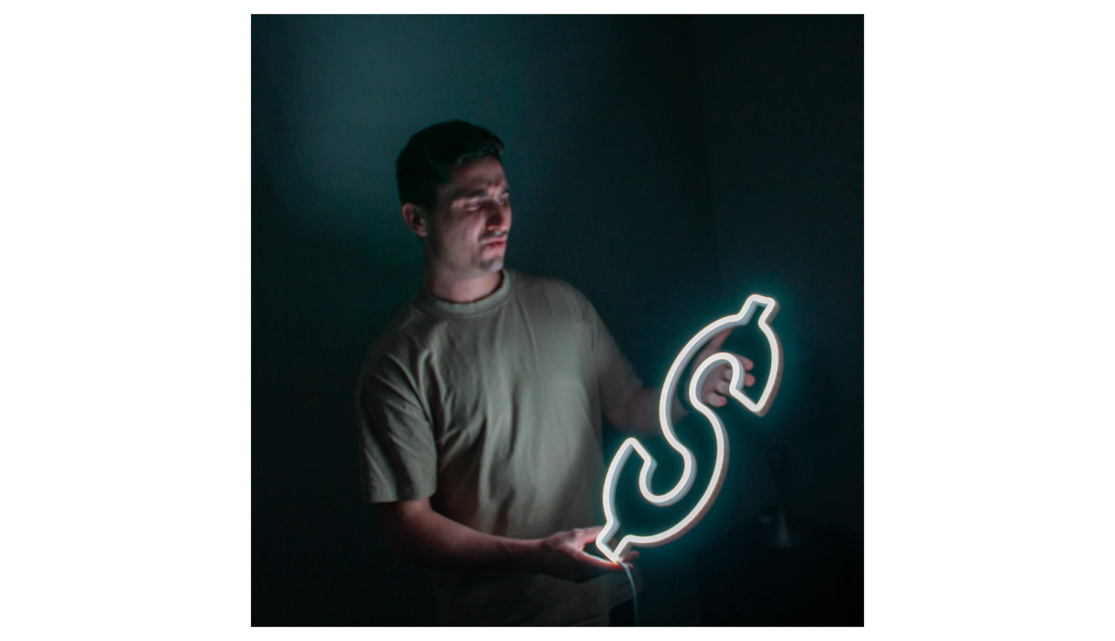 a man holding a lit up dollar sign