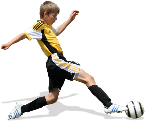 a young boy kicking a soccer ball