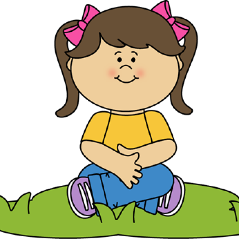 a little girl sitting on the grass