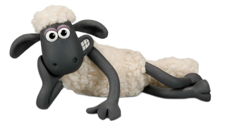 a stuffed sheep laying down on the ground