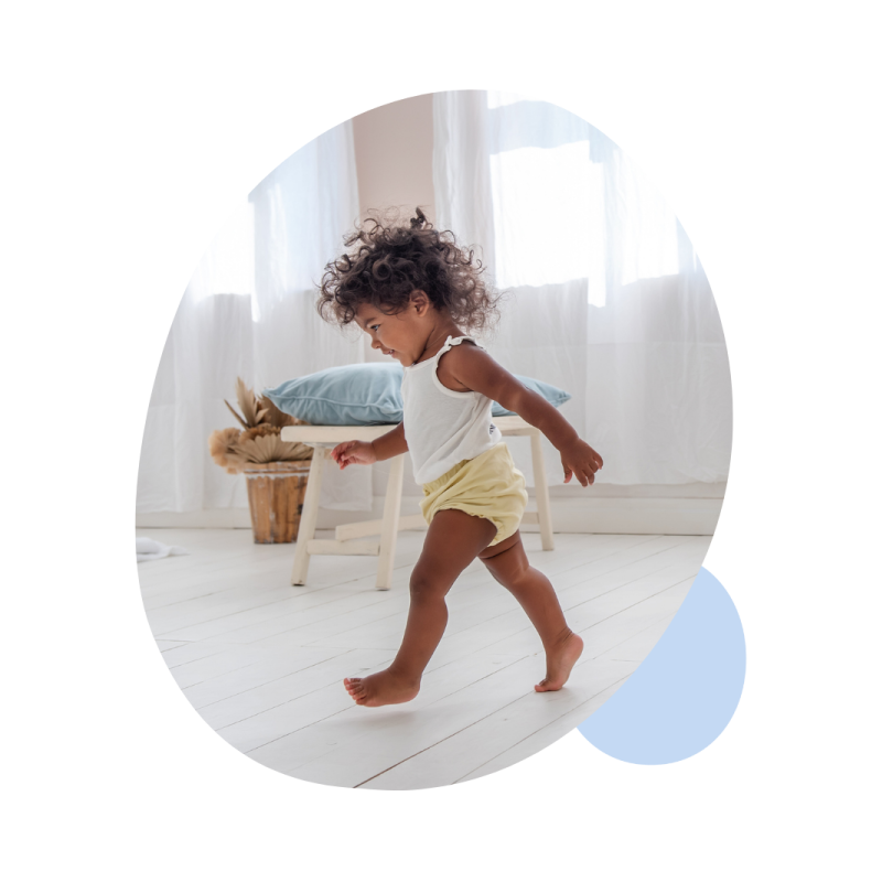 a baby running on the floor in a white room