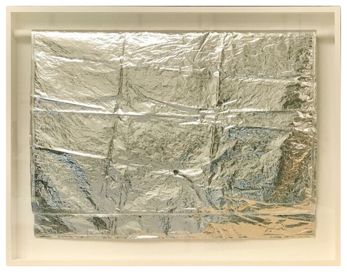 a piece of aluminum foil in a white frame