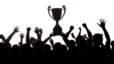 a crowd of people raising their hands in front of a trophy