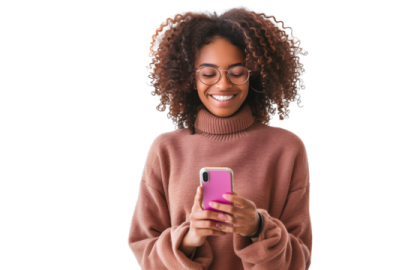 a woman in a pink sweater holding a cell phone