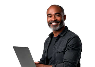 a man is smiling while using his laptop