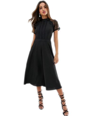 a woman wearing a black dress and sandals