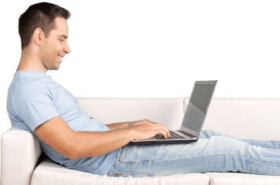 a man sitting on a couch using a laptop