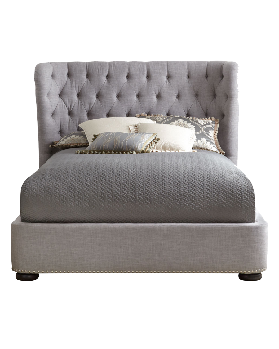 a bed with a gray headboard and pillows