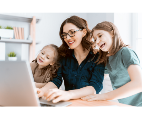 a woman and two young girls looking at a laptop