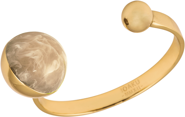 a close up of a gold cuff with an oval stone